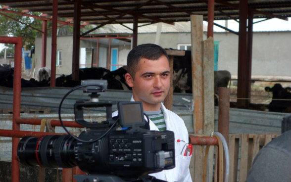 Das Bild zeigt Giorgi, der den Kameramann über die Kamera hinweg anschaut. 