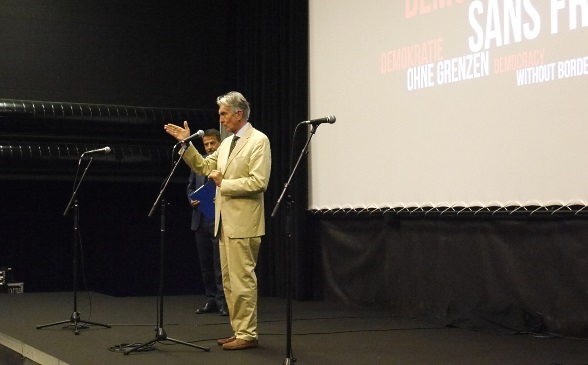 Marco Solari, the director of the film festival, stands behind a microphone giving his speech.