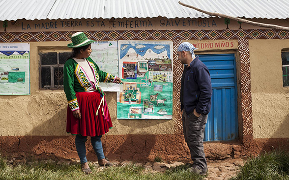 A man and woman stand in front of a poster.