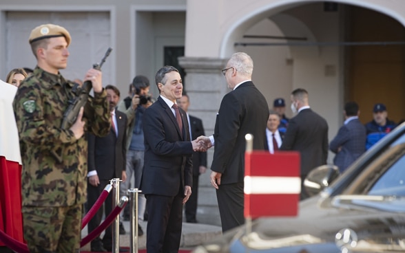 Le président de la Confédération, Ignazio Cassis, a accueilli le chef d’État letton, Egils Levits, sur la Piazza Riforma à Lugano. (© Keystone, Pablo Gianinazzi) Alt-text  Le président de la Confédération Ignazio Cassis serre la main au chef d’État letton, Egils Levits, sur la Piazza Riforma à Lugano