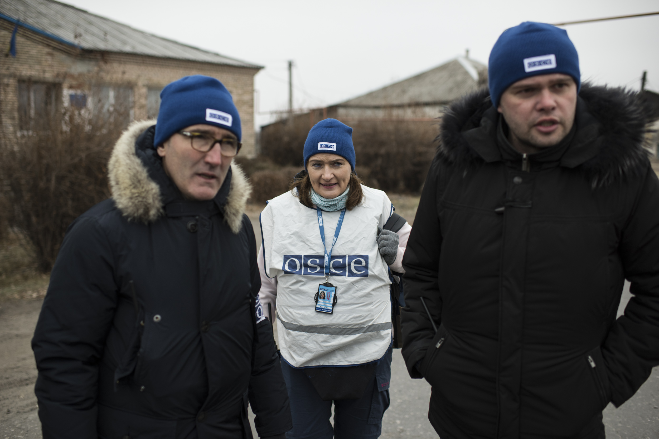 Drei OSZE-Beobachter auf einer Strasse.