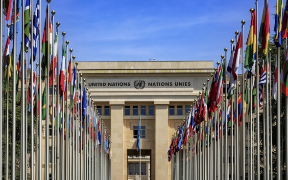 the ‘Palais des Nations’ building in Geneva and its flag-lined route stand out in the night.