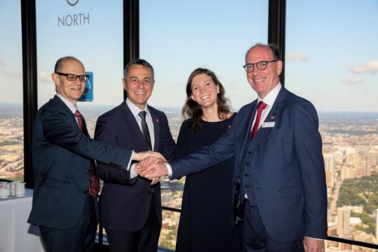 Federal Councillor Ignazio Cassis, a woman and two men employed at the consulate General in Chicago, are holding hands.