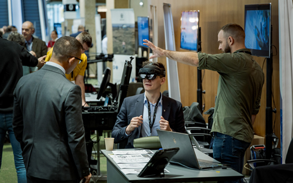 Un partecipante alla conferenza prova una cuffia per la realtà virtuale.