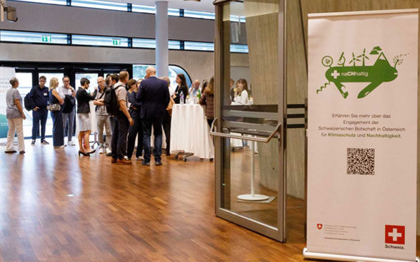 Evento presso l’Ambasciata con in vista un cartellone raffigurante il «coltellino tascabile verde».