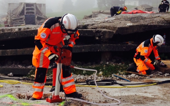 Quattro membri della Catena di salvataggio impegnati durante la simulazione di un terremoto in un’area di Epeisses.