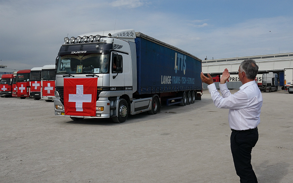 Il consigliere federale Didier Burkhalter applaude alla partenza del convoglio umanitario svizzero.