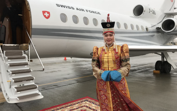 Una donna in costume tradizionale posa davanti all’aereo della Swiss Air Force all’aeroporto di Ulan Bator.