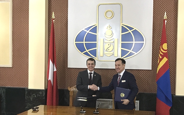 Il consigliere federale Cassis e il suo omologo mongolo Damdin Tsogtbaatar si stringono la mano in occasione di un incontro ufficiale.