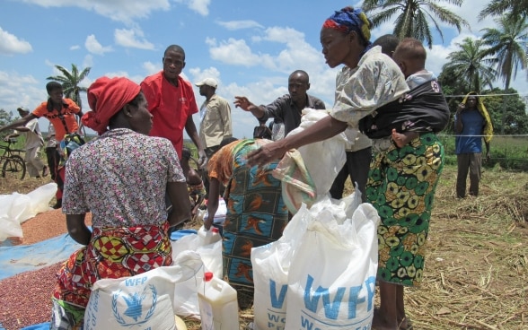 La gente condivide le razioni di fagioli in un sito di distribuzione del Programma alimentare mondiale delle Nazioni Unite nella regione congolese del Kasai, colpita dalla crisi.