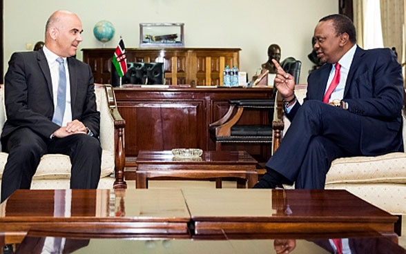 President Berset and Kenyan President Kenyatta sit at a wooden table and discuss.