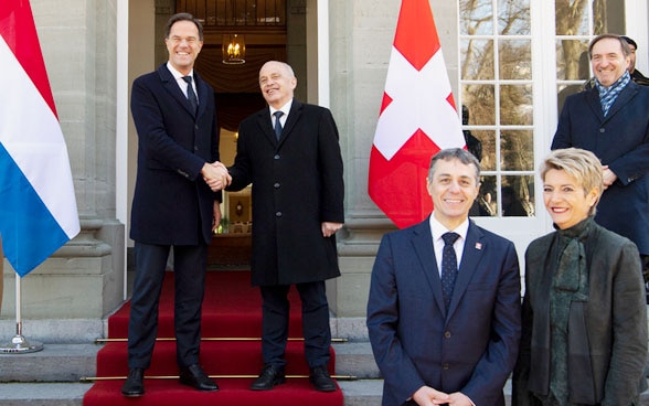 Il primo ministro olandese Mark Rutte (centro-sinistra) e Ueli Maurer, presidente della Confederazione svizzera (centro-destra) si stringono la mano in presenza del  consigliere federale Ignazio Cassis (terzo a destra) e della consigliera federale Karin Keller-Sutter (seconda a destra) prima del loro incontro nella residenza Lohn.  