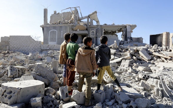 Des enfants yéménites inspectent un bâtiment détruit par des raids aériens à Sanaâ. 