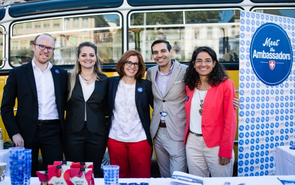 Un gruppo di cinque ambasciatrici e ambasciatori posa davanti all’autobus per la foto