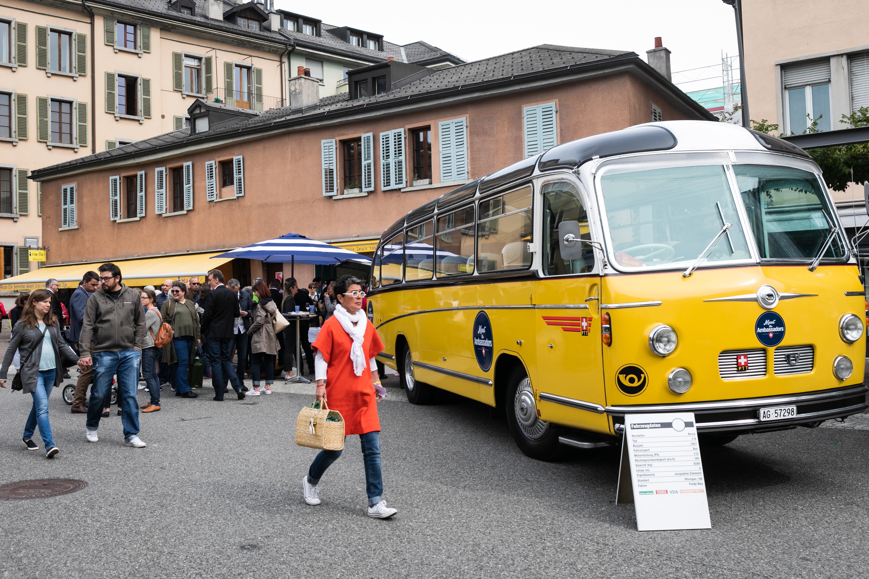 Bevölkerung von Sion im Gespräch am Stand der Botschafter; im Vordergrund das Postauto Meet the Ambassador