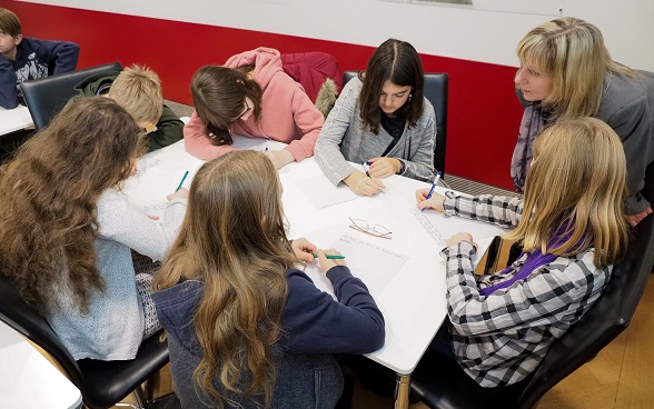 I bambini scrivono su un foglio di carta.