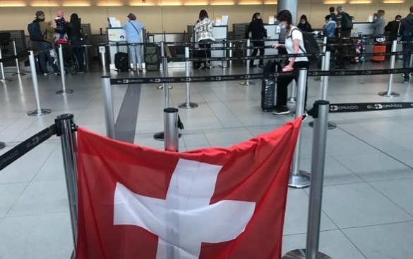 In the hall of the airport of Bogotà a Swiss flag hanging at the check-in counter indicates the flight to Switzerland.