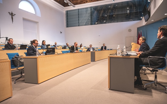 Im Parlamentssaal von Bellinzona diskutiert Bundesrat Cassis mit den Delegationen der Regierungen des Kantons Graubünden und des Kantons Tessin. Rechts neben Bundesrat Cassis sitzt Staatssekretär Balzaretti.