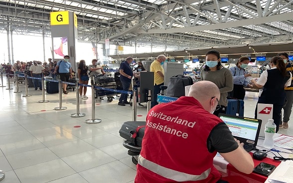 A l’aéroport de Bangkok, du personnel de l’ambassade de Suisse prête assistance aux voyageurs enregistrés sur le vol Bangkok-Zurich.