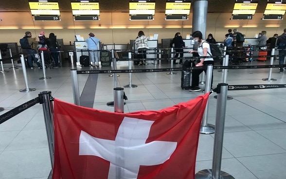 Eine Schweizer Fahne am Flughafen von Bogotá zeigt den Reisenden den Check-in-Schalter für den nächsten Flug nach Zürich. 