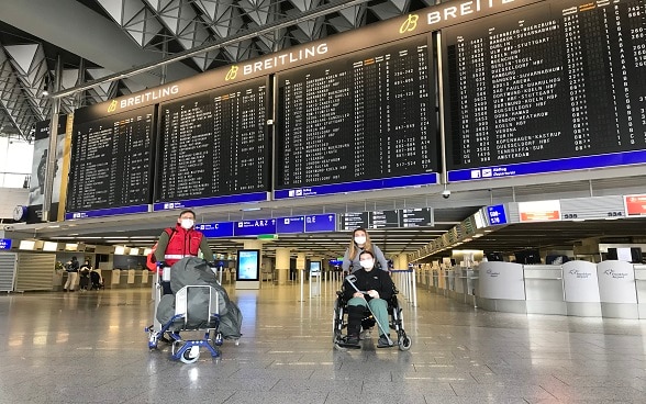 Drei Schweizer Bürger werden auf dem Frankfurter Flughafen, nachdem das Flugzeug aus Kathmandu gelandet ist, fotografiert. 