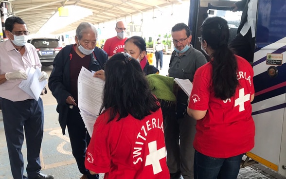 Passengers get off a bus at the entrance of Goa airport in India. They are greeted by staff from the local Swiss representations. 