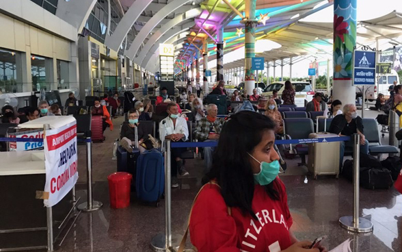 I passeggeri del volo Goa-Zurigo sono in attesa nell'atrio dell'aeroporto di Goa. 