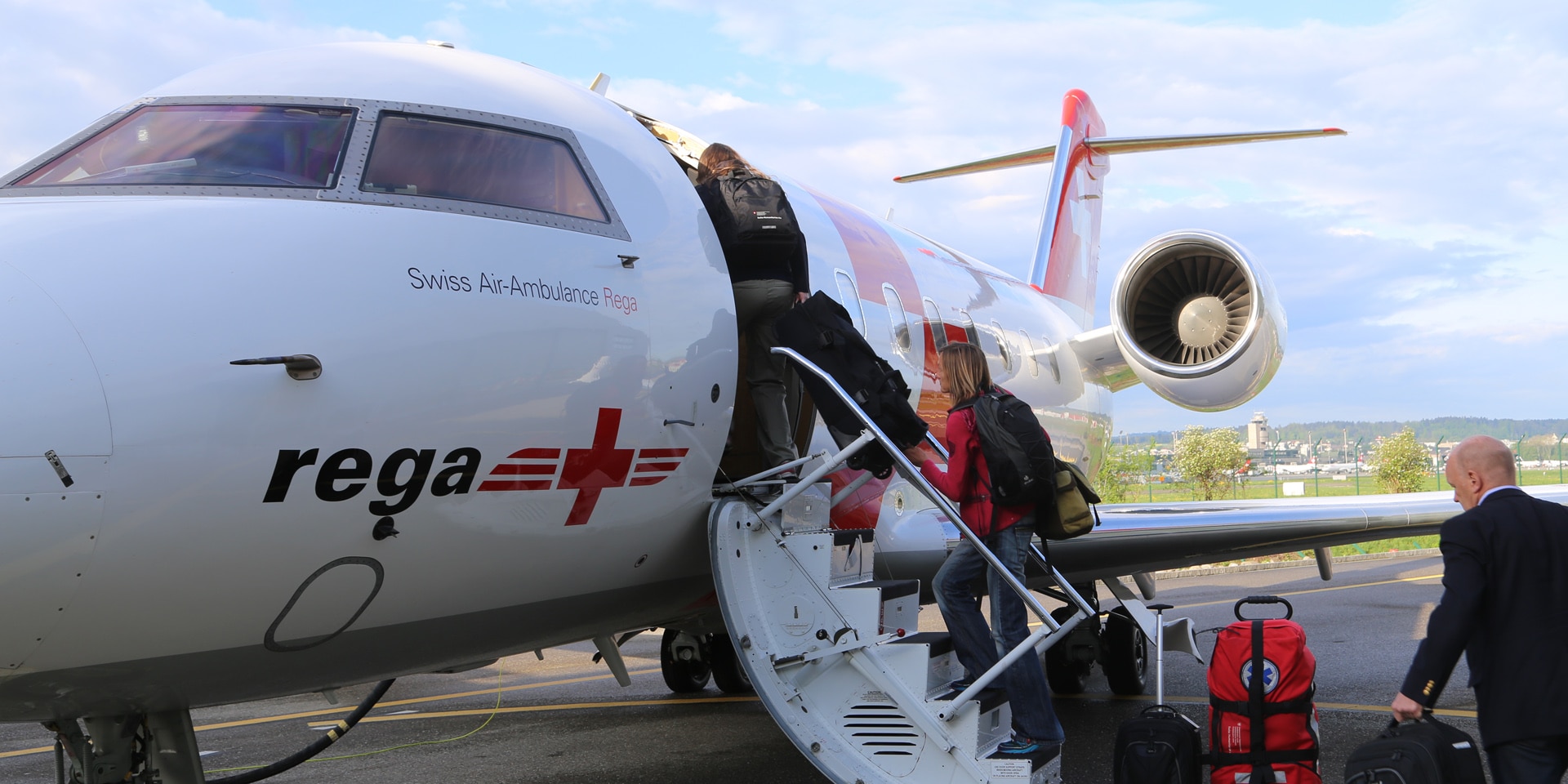Das Soforteinsatzteam des Schweizerischen Korps für Humanitäre Hilfe besteigt ein weisses Flugzeug der REGA, das am Flughafen Zürich auf dem Rollfeld steht.