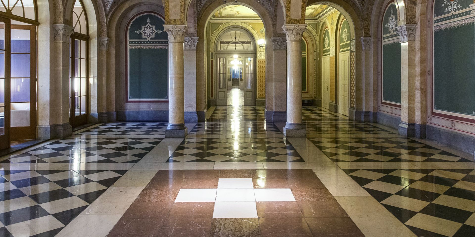 Vue sur l'intérieur de la Maison Ouest du gouvernement fédéral avec une croix suisse sur le sol. 