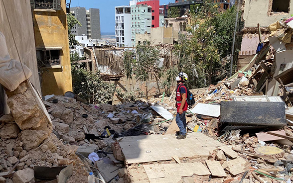 Un esperto dell’Aiuto umanitario della Confederazione si trova davanti alle rovine di una casa distrutta dall’esplosione.