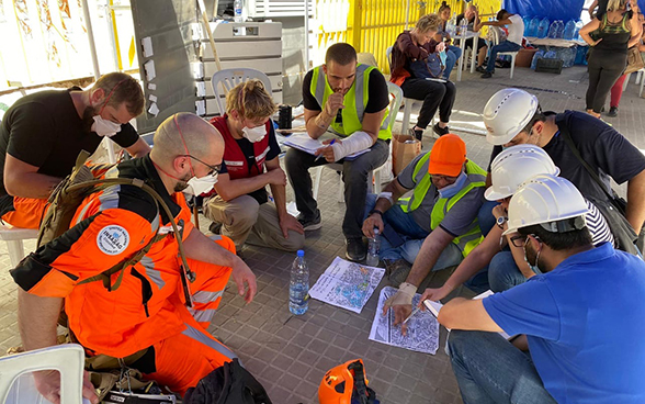 Experten der der Humanitären Hilfe des Bundes besprechen einen Ortsplan.