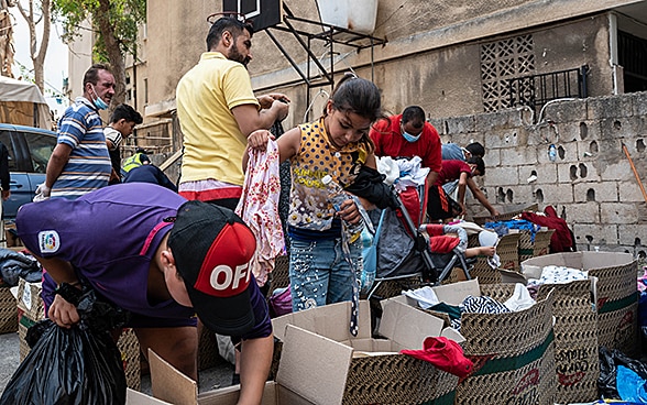 Residents dig through boxes of donated clothes. 