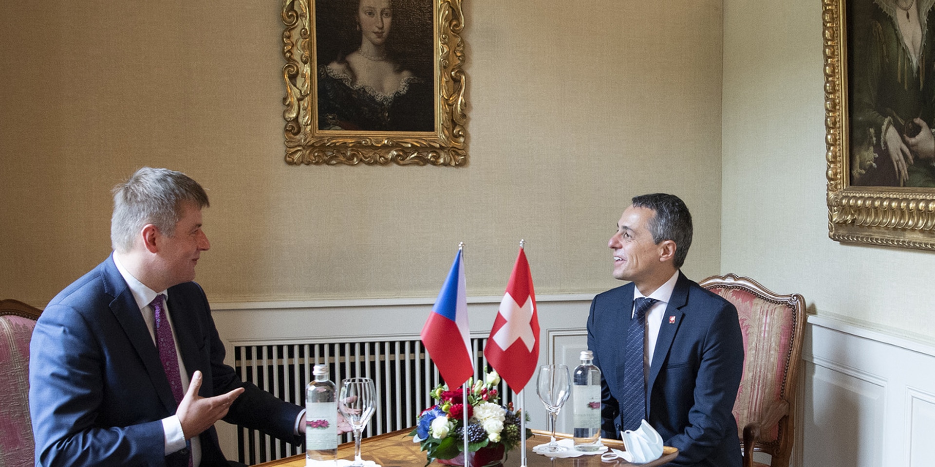 Ignazio Cassis and Tomáš Petříček are talking while sitting at a table.