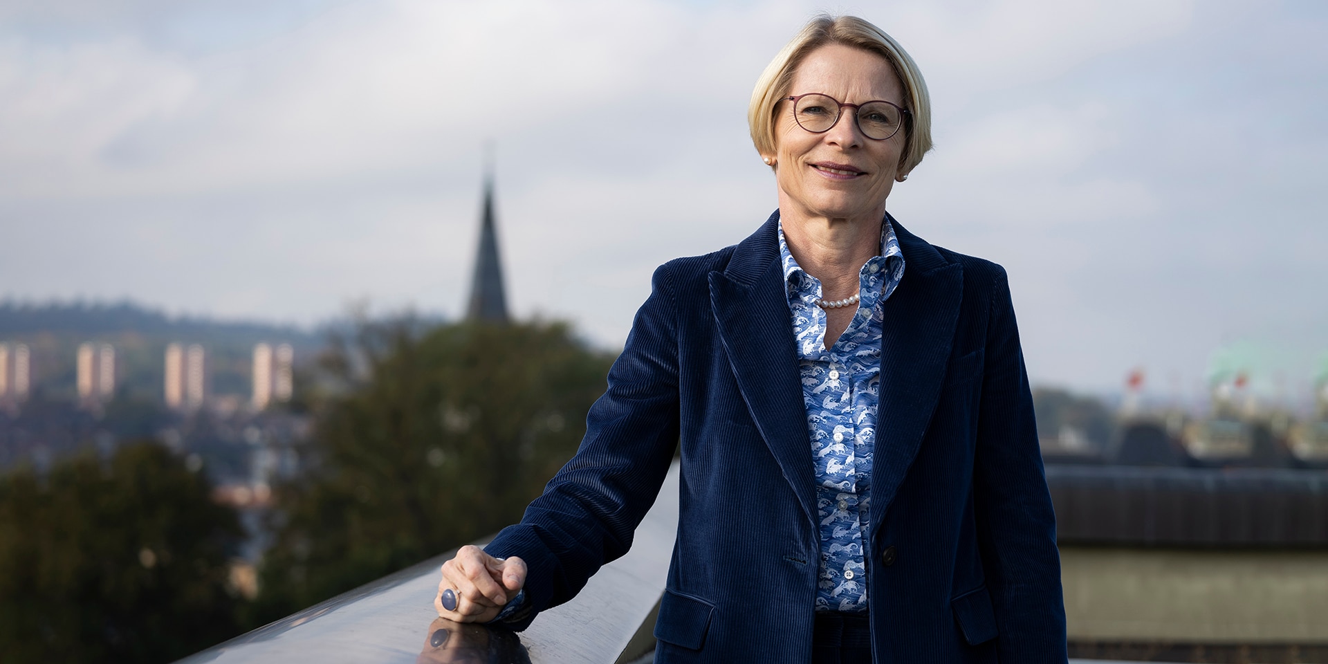 Livia Leu steht auf dem Balkon des Bundeshauses und schaut in die Kamera. 