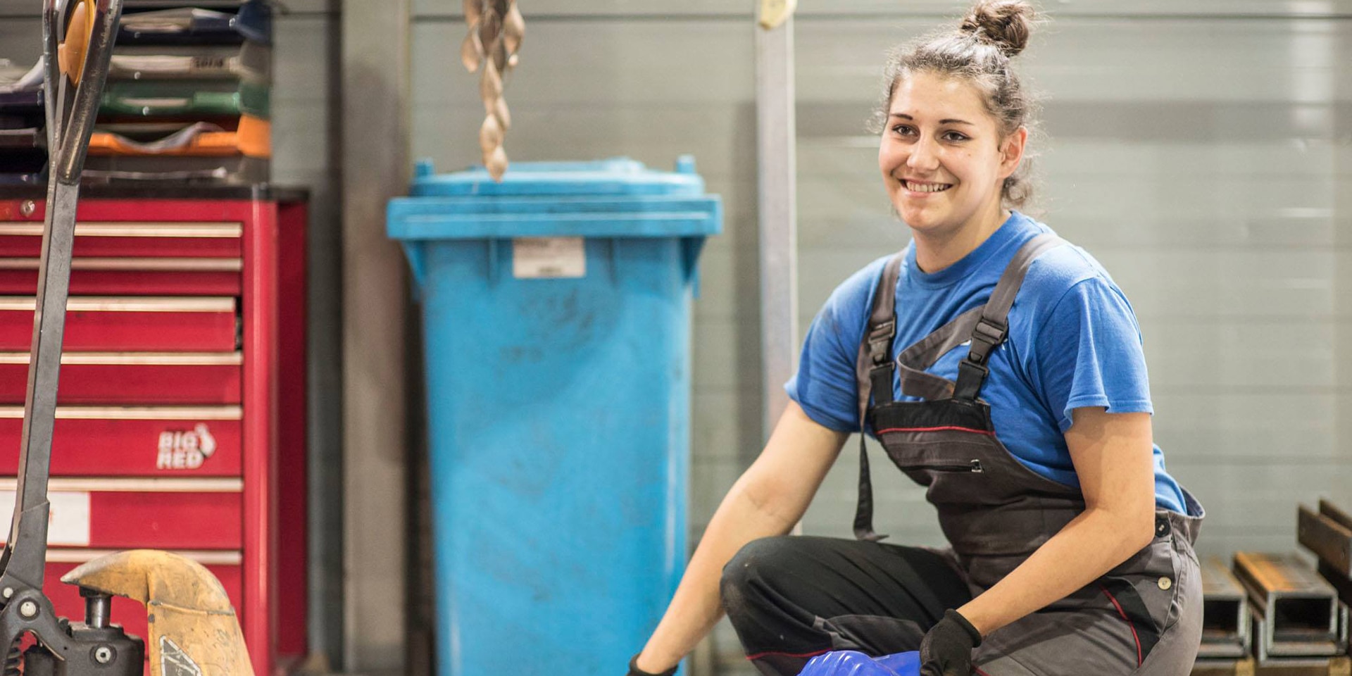  Une jeune femme dans une usine sourit à la caméra