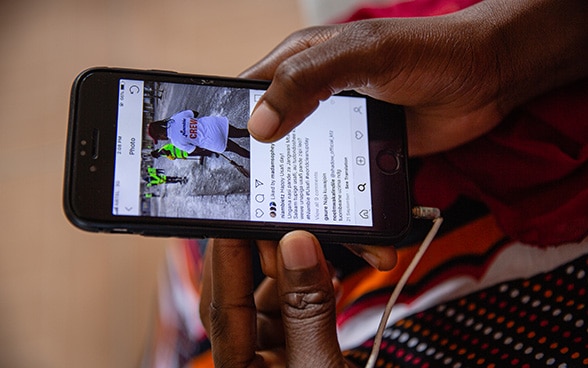 Une personne africaine tient un smartphone dans ses mains