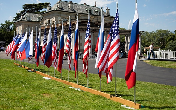Im Hintergrund ist die Villa La Grange zu sehen, im Vordergrund sind amerikanische und russische Flaggen in einer Reihe aufgestellt.