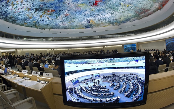 L'image, prise avec un objectif fisheye, montre une vue générale de l'assemblée du Conseil des droits de l'homme au siège européen des Nations unies à Genève.