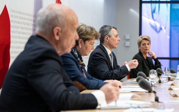 Vier Mitglieder des Bundesrates sitzen an einem grossen Pult. 