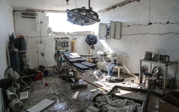 View of a destroyed operating theatre in a Syrian hospital. There is a large hole in a wall.