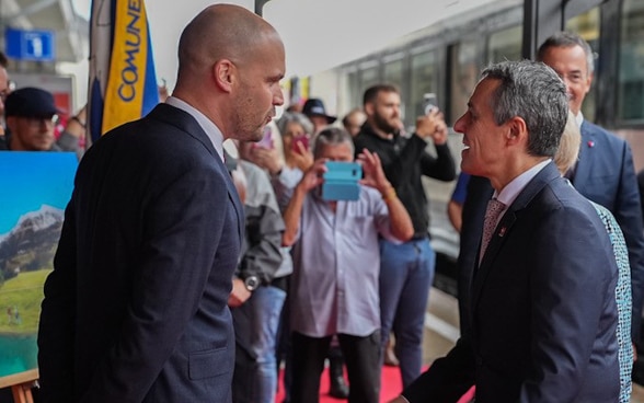 Il presidente della Confederazione è accolto sul binario della stazione ferroviaria di Airolo dalle autorità e dalla popolazione. 