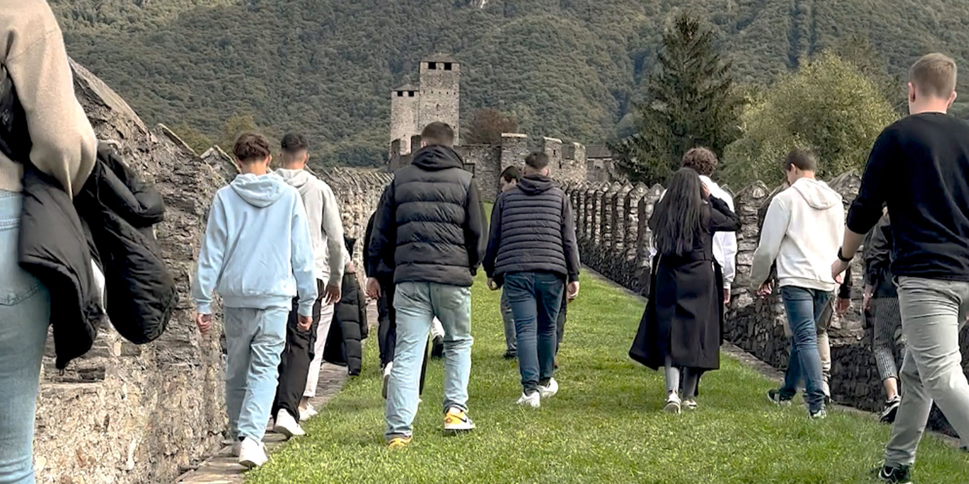 Un gruppo di giovani cammina sulle mura di Castelgrande a Bellinzona.