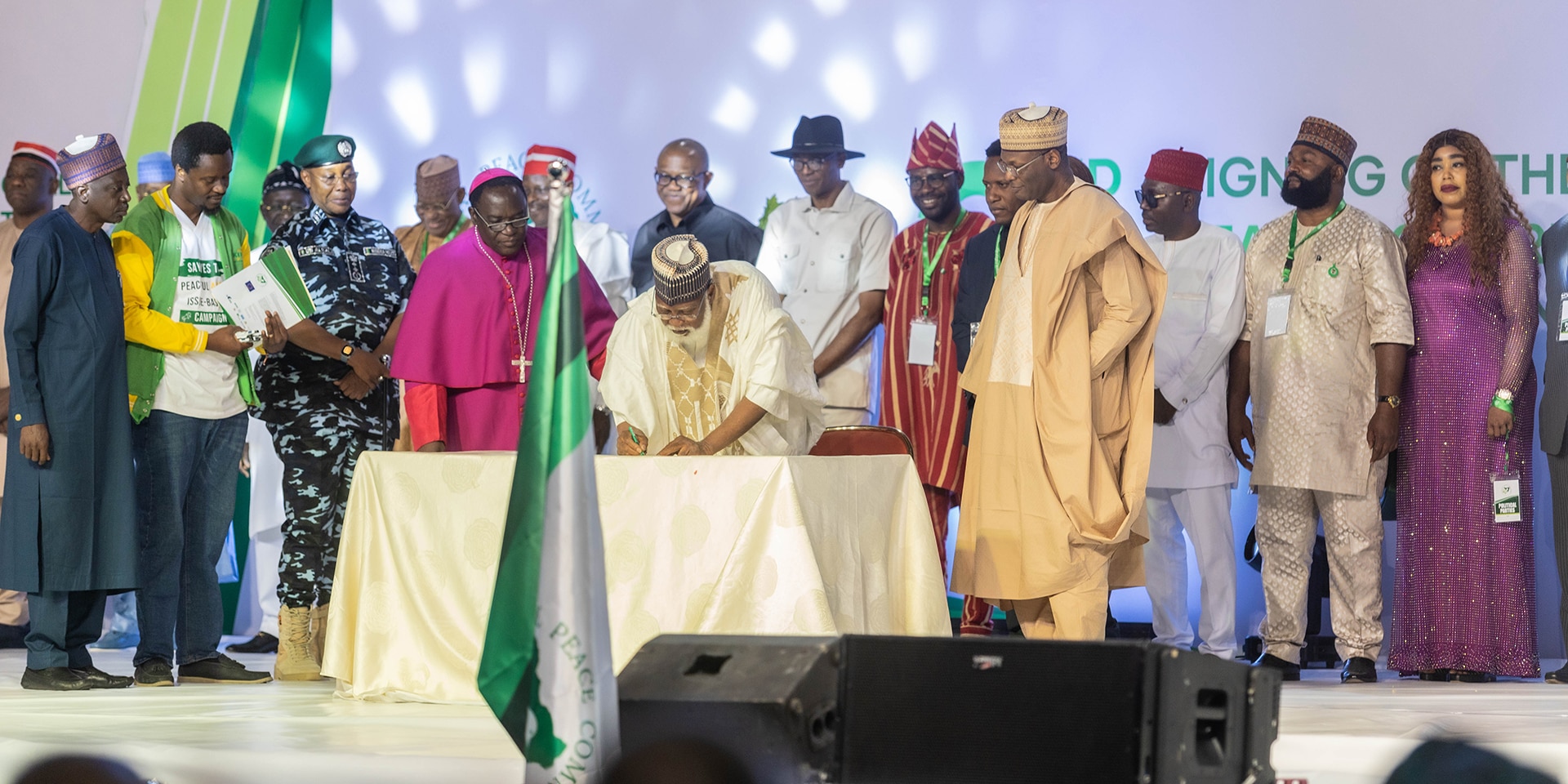 On a stage, the presidential candidates sign the "National Peace Accords".