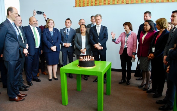 Les représentants du groupe ACT posent autour d'un gâteau.