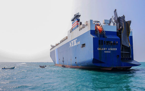 The blue and white cargo ship "Galaxy Leader" anchors on turquoise waters in the Red Sea off the Yemeni coast.