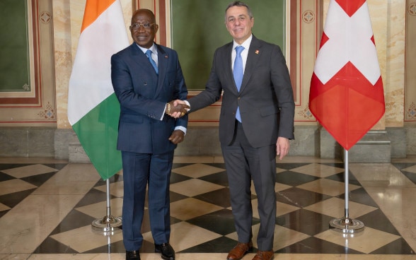 Bundesrat Ignazio Cassis schüttelt dem Aussenminister von der Elfenbeinküste Kacou Houadja Léon Adom die Hand.