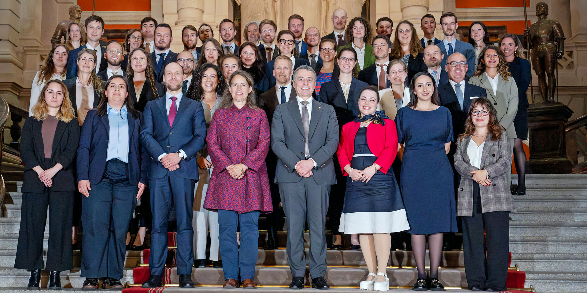 Die Mitglieder der Volées 2024-2025 und Bundesrat Ignazio Cassis stehen in einer Gruppe zusammen.