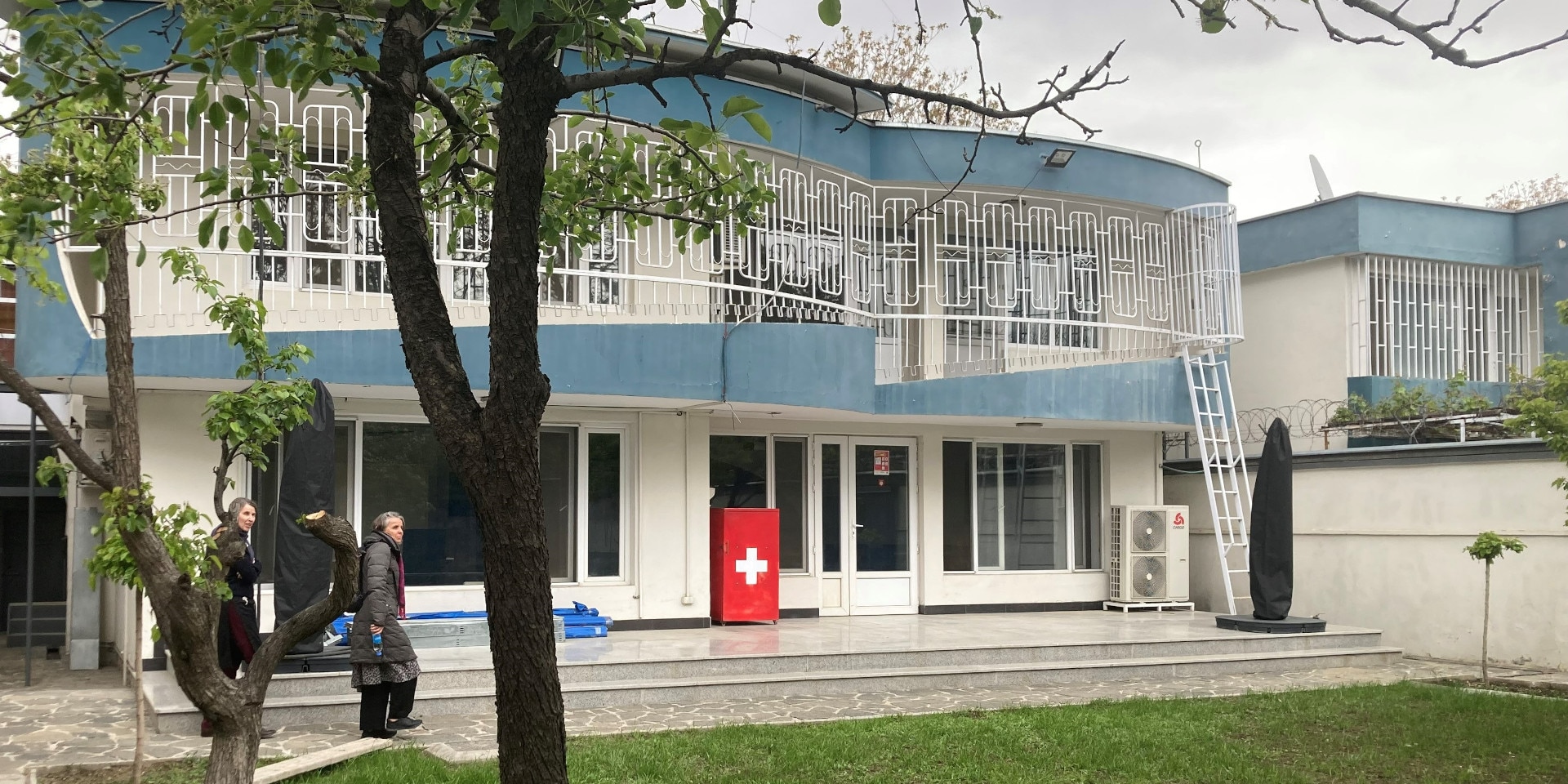 Ansicht des Gebäudes des humanitären Büros der Schweiz in Kabul. Im Vordergrund Rasen und zwei Bäume.