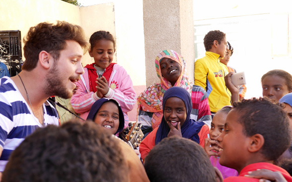Durant son séjour en Egypte, Bastian Baker a partagé un moment musical avec les enfants du village d’Armena. © DDC
