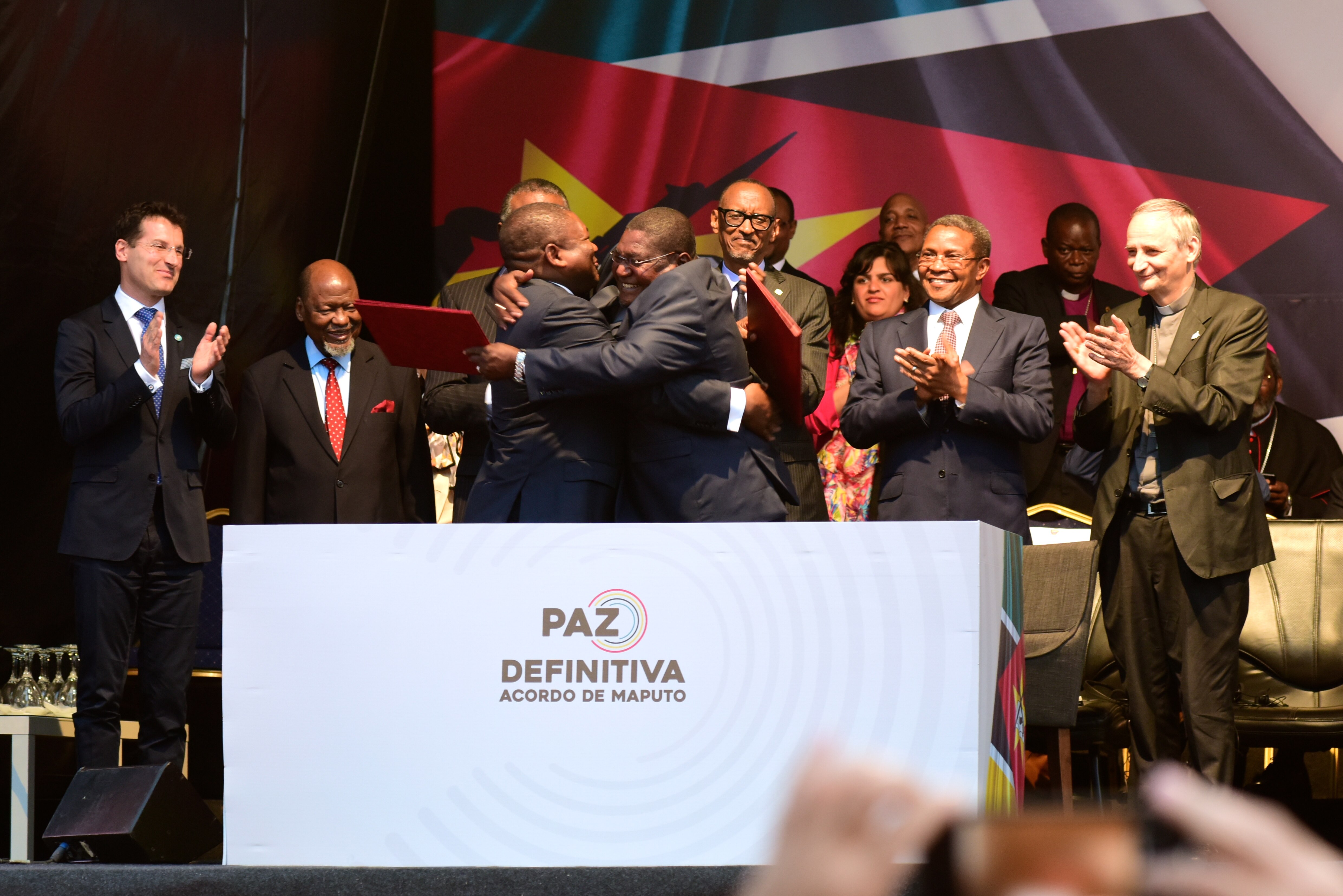 Il presidente del Mozambico Nyusi e il leader dell’ex gruppo ribelle Renamo, Momade, si abbracciano alla cerimonia di pace dopo decenni di violenza.